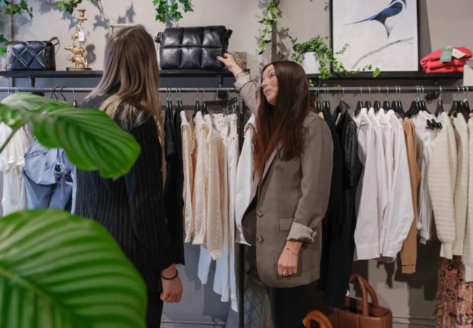 Butiksbiträde som hjälper kund i klädbutik i Umeå